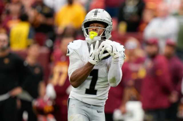Jalen Tolbert em um uniforme branco do Dallas Cowboys com o número 1, correndo com uma bola de futebol.