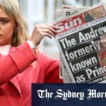 Um repórter segura um exemplar do jornal The Sun do lado de fora dos portões do Royal Lodge.