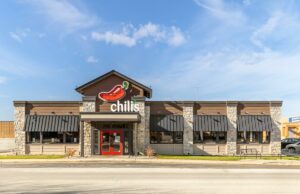 O curso do Chili reverte e traz de volta o favorito dos fãs após a revolta dos clientes Edifício do restaurante Chili's Bar and Grill com um grande logotipo de pimenta.