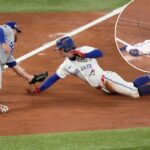 Ernie Clement, do Toronto Blue Jays, é eliminado pelo terceiro base do Los Angeles Dodgers, Max Muncy.
