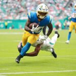 O running back do Los Angeles Chargers, Kimani Vidal (30), carrega a bola contra o cornerback do Miami Dolphins, Jack Jones (23), durante o terceiro quarto no Hard Rock Stadium.