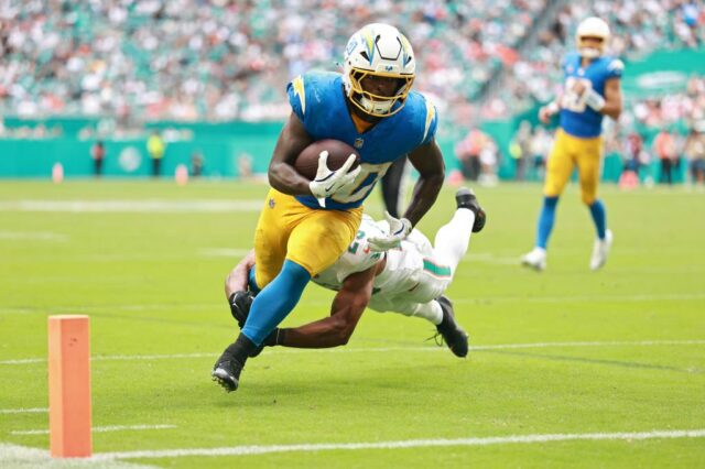 O running back do Los Angeles Chargers, Kimani Vidal (30), carrega a bola contra o cornerback do Miami Dolphins, Jack Jones (23), durante o terceiro quarto no Hard Rock Stadium. 