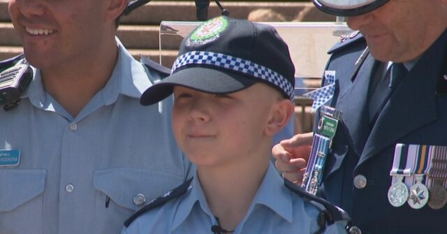 Bryson, de 12 anos, em um uniforme da polícia após seu dia Make-A-Wish, em colaboração com a polícia de NSW.