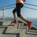 A person runs up stairs near the ocean.