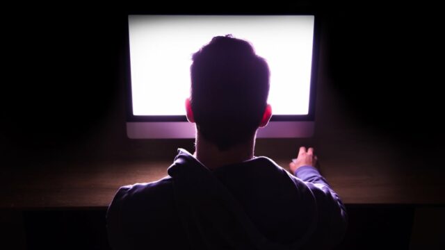Um homem olha para a tela de um computador.
