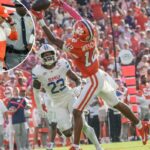 O wide receiver do Clemson Tigers, Bryant Wesco Jr., tenta pegar um passe enquanto o safety do Southern Methodist Mustangs, Isaiah Nwokobia, defende.