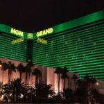 Exterior do hotel MGM Grand em Las Vegas, uma luz verde brilhou no edifício. Palmeiras estão alinhadas na frente. O relatório financeiro do terceiro trimestre da MGM Resorts chegou, com a China vendo um aumento
