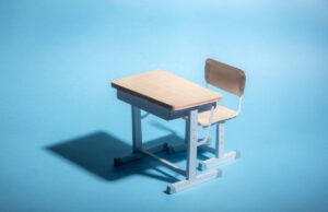 O sistema de segurança e proteção de IA do ensino médio deixa perplexo a bolsa Doritos em busca de uma arma viável Empty school desk on a blue background. .