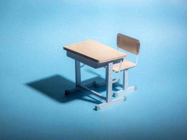 O sistema de segurança e proteção de IA do ensino Empty school desk on a blue background. .
