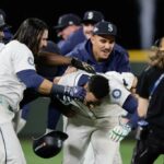 Jorge Polanco (centro) é assediado por companheiros de equipe depois de marcar uma única vitória no 15º turno da vitória dos Mariners sobre os Tigers no jogo 5 do ALDS em 10 de outubro de 2025.