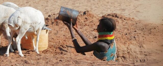 Duas mulheres turkana carregando água através da paisagem árida
