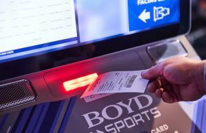 Os jogos para PC da Boyd alcançam receitas de US$ 1 bilhão no terceiro trimestre, afirma o recorde Close de uma mão pegando um pedaço de papel semelhante a um recibo de um. Máquina Boyd Sports. Boyd Gaming atinge receita de US$ 1 bilhão no terceiro trimestre, afirma relatório