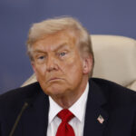 Um grupo de mineiros de carvão distribui cartazes antes da chegada do presidente Donald Trump em um comício de campanha no aeroporto do condado de Altoona-Blair em Martinsburg, Pensilvânia, segunda-feira, 26 de outubro de 2020. (AP Photo/Gene J. Puskar)