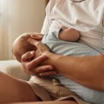 A jovem mãe está amamentando seu bebê recém-nascido.