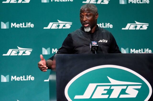 O técnico do New York Jets, Aaron Glenn, fala em um pódio.