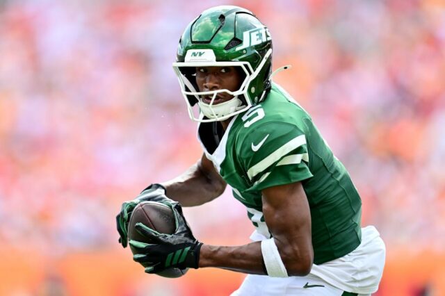 Dois jogadores do Dallas Cowboys enfrentam um jogador do New York Jets.