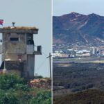 Um soldado norte-coreano em um posto de guarda militar com uma bandeira nacional hasteada acima, visto de Paju, Coreia do Sul.
