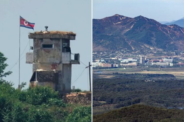 Um soldado norte-coreano em um posto de guarda militar com uma bandeira nacional hasteada acima, visto de Paju, Coreia do Sul.