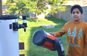 #TheMoment, um astrônomo de 12 anos encontrou 2 planetas Um menino está ao lado de um telescópio