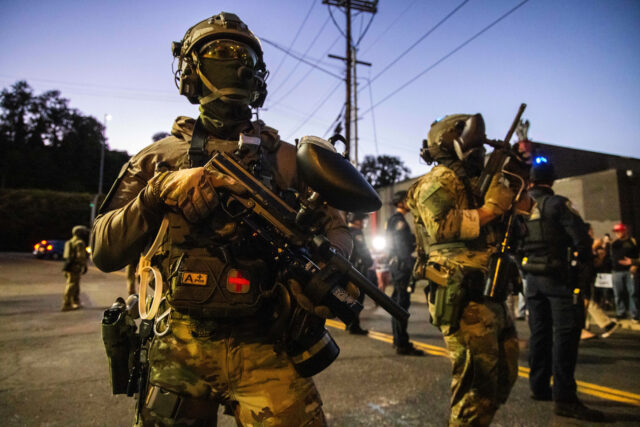 Um manifestante é preso pela polícia e oficiais federais do lado de fora de uma instalação de Imigração e Alfândega dos EUA em Portland, Oregon, segunda-feira, 6 de outubro de 2025. (AP Photo/Ethan Swope)