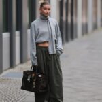 HAMBURGO, ALEMANHA - 19 DE SETEMBRO: Aylin K√∂nig é vista vestindo um suéter de malha solto e grosso, sem mangas, com zíper em um tom bege suave, gola larga e caimento descontraído; jeans azul claro com perna reta e corte levemente largo; sandálias de salto com tiras nude; uma bolsa clutch estilo tecido bege com textura acolchoada; pulseiras de ouro empilhadas da Cartier; um relógio com pulseira metálica e mostrador branco da Cartier; anéis detalhados em ouro; brincos de ouro da coleção Tiffany & Co HardWear; óculos de sol retangulares pretos; seu cabelo escuro está preso em um coque baixo e elegante em 19 de setembro de 2025 em Hamburgo, Alemanha. (Foto de Moritz Scholz/Getty Images)