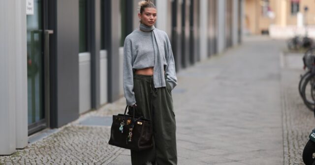 HAMBURGO, ALEMANHA - 19 DE SETEMBRO: Aylin K√∂nig é vista vestindo um suéter de malha solto e grosso, sem mangas, com zíper em um tom bege suave, gola larga e caimento descontraído; jeans azul claro com perna reta e corte levemente largo; sandálias de salto com tiras nude; uma bolsa clutch estilo tecido bege com textura acolchoada; pulseiras de ouro empilhadas da Cartier; um relógio com pulseira metálica e mostrador branco da Cartier; anéis detalhados em ouro; brincos de ouro da coleção Tiffany & Co HardWear; óculos de sol retangulares pretos; seu cabelo escuro está preso em um coque baixo e elegante em 19 de setembro de 2025 em Hamburgo, Alemanha. (Foto de Moritz Scholz/Getty Images)