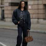 PARIS, FRANÇA - 16 DE MAIO: Natalia Verza @mascarada.paris usa um boné de couro preto, uma jaqueta blazer oversized de linho bege da Aeron, uma camiseta branca cortada, calça jeans branca rasgada, uma bolsa Prada Cleo branca, sapatos de salto alto pontiagudos da Louboutin, em 16 de maio de 2021 em Paris, França. (Foto de Edward Berthelot/Getty Images)