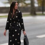 Gili Biegun usa calças compridas creme de seda e top combinando com detalhes no pescoço da Aeron, bolsa quadrada de couro preta da Aeron, luvas longas de couro preto, casaco de pele sintética extra grande e salto Saint Laurent em 03 de dezembro de 2024 em Copenhague, Dinamarca.