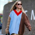 Victoria Magrath usa um pulôver de lã laranja vermelho e rosa com gola alta, saia plissada de renda preta e bolsa de couro preta, durante a London Fashion Week de setembro de 2019 em 15 de setembro de 2019 em Londres, Inglaterra.