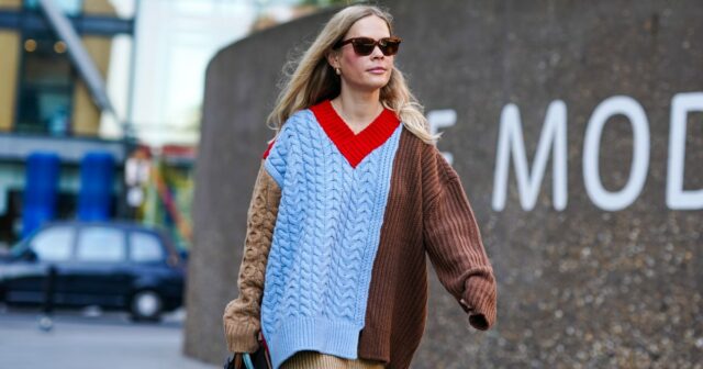 Victoria Magrath usa um pulôver de lã laranja vermelho e rosa com gola alta, saia plissada de renda preta e bolsa de couro preta, durante a London Fashion Week de setembro de 2019 em 15 de setembro de 2019 em Londres, Inglaterra.
