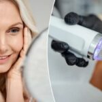 Mulher de meia idade feliz tocando seu rosto e sorrindo para um espelho.