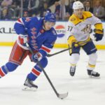 O ala direito do New York Rangers, Gabe Perreault (94), move o disco no gelo durante o primeiro período contra o Nashville Predators.