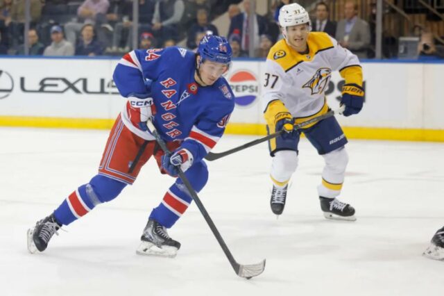 O ala direito do New York Rangers, Gabe Perreault (94), move o disco no gelo durante o primeiro período contra o Nashville Predators.