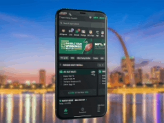 A gigante do jogo Caesars se prepara para a data de lançamento das apostas esportivas no Missouri A gigante do jogo Caesars se prepara para a data de lançamento das apostas esportivas no Missouri. Um smartphone exibindo a interface do aplicativo Caesars Sportsbook flutua em frente a uma paisagem urbana turva à noite. A tela do aplicativo mostra opções de apostas esportivas, incluindo promoções da NFL, linhas de jogos e uma aposta de futebol nas noites de quinta-feira. O fundo inclui um horizonte ribeirinho com reflexos brilhantes e uma grande estrutura em forma de arco.