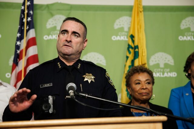 O chefe de polícia de Oakland, Floyd Mitchell, à esquerda, observa enquanto a prefeita de Oakland, Barbara Lee, faz o discurso do estado de Oakland na Prefeitura de Oakland em Oakland, Califórnia, na terça-feira, 7 de outubro de 2025. (Ray Chavez/Bay Area News Group)