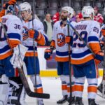 Emil Heineman nº 51 do New York Islanders bate capacete com o companheiro de equipe Ilya Sorokin nº 30 após a vitória eliminatória contra o Detroit Red Wings durante o terceiro período na Little Caesars Arena em 20 de novembro de 2025 em Detroit, Michigan.