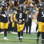 O quarterback do Pittsburgh Steelers, Aaron Rodgers (8), segura seu braço após uma rebatida do Cincinnati Bengals.