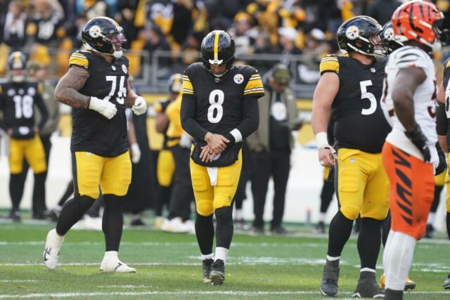 O quarterback do Pittsburgh Steelers, Aaron Rodgers (8), segura seu braço após uma rebatida do Cincinnati Bengals.