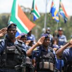 Uma activista da Greenpeace segura uma faixa ao juntar-se a uma projecção da Equipa de Acções de Glasgow que apela a uma reforma ousada da dívida, uma acção climática mais forte e respostas urgentes à crise de desenvolvimento global, enquanto os líderes se preparam para a primeira cimeira do G20 organizada em África, em Joanesburgo, África do Sul, em 19 de Novembro de 2025.