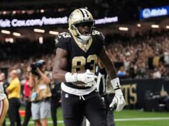 Almeje essas meias em posição fina no futebol fantasia Um jogador da NFL com uniforme branco com número 88 e pintura no rosto grita.