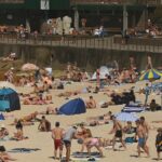 O sol torna o céu da manhã vermelho ao romper as nuvens na Gold Coast de Queensland.
