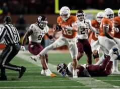 Arch Manning, Texas, estraga a tentativa da Texas A&M de uma temporada invicta para manter vivas as esperanças do CFP O quarterback do Texas Longhorns, Arch Manning, corre para um touchdown com um jogador do Texas A&M Aggies no chão.