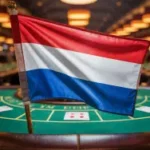 Uma fotografia da bandeira da Holanda exibida com destaque em primeiro plano, de um cassino. Autoridade holandesa de jogos de azar emite aviso à Tulipa Entertainment por violações