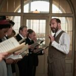 Roger Allam como Alderman Duxbury e Ralph Fiennes como Dr. Guthrie, Amara Okereke como Mary, Alun Armstrong em The Choral