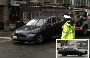 Bruto que esmagou rival até a morte com seu próprio carro em briga em Nova York, enviado para a prisão por ‘crueldade chocante’ Um carro escuro danificado sendo rebocado em uma rua da cidade.