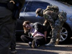 Charlotte’s Web: O que está acontecendo com as operações de imigração na Carolina do Norte? Um manifestante fantasiado de sapo inflável se aproxima de um policial durante um protesto em frente ao escritório do Departamento de Segurança Interna