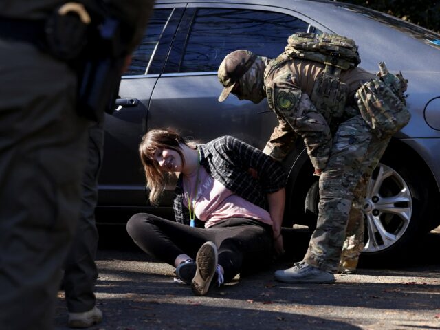 Um manifestante fantasiado de sapo inflável se aproxima de um policial durante um protesto em frente ao escritório do Departamento de Segurança Interna