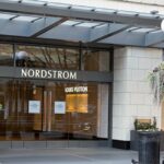 Victoria Magrath usa um pulôver de lã laranja vermelho e rosa com gola alta, saia plissada de renda preta e bolsa de couro preta, durante a London Fashion Week de setembro de 2019 em 15 de setembro de 2019 em Londres, Inglaterra.