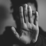 China força Apple a remover os aplicativos de namoro gay mais populares | Foto de uma mulher segurando a mão em um gesto de parada