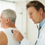 A doctor examines an older patient.